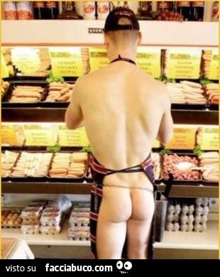 Ragazzo nudo con grembiule al bancone del frigo del supermercato